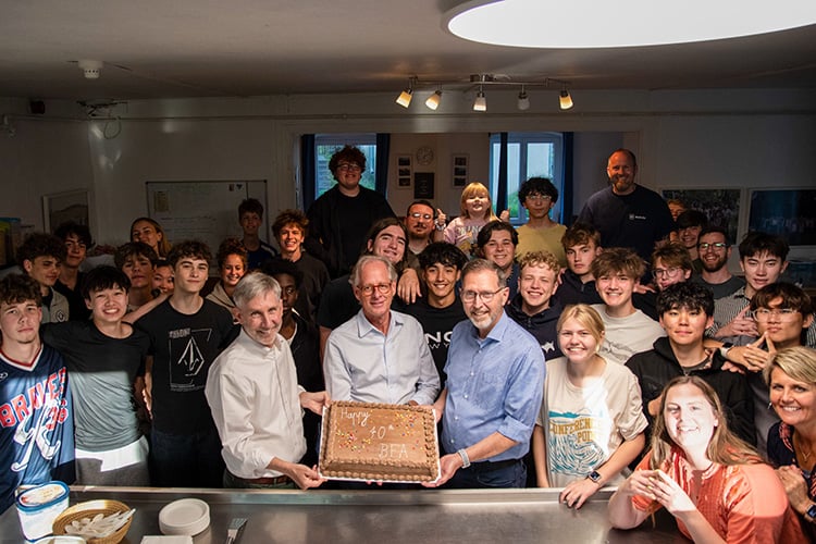 Holding up a cake for the 70 year anniversary